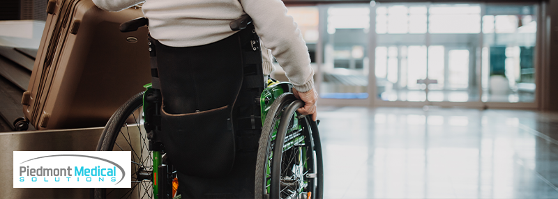 Man in wheelchair grabbing suitcase at airport
