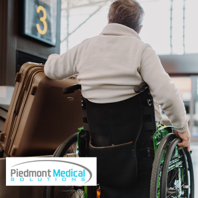 Man in wheelchair grabbing suitcase at airport